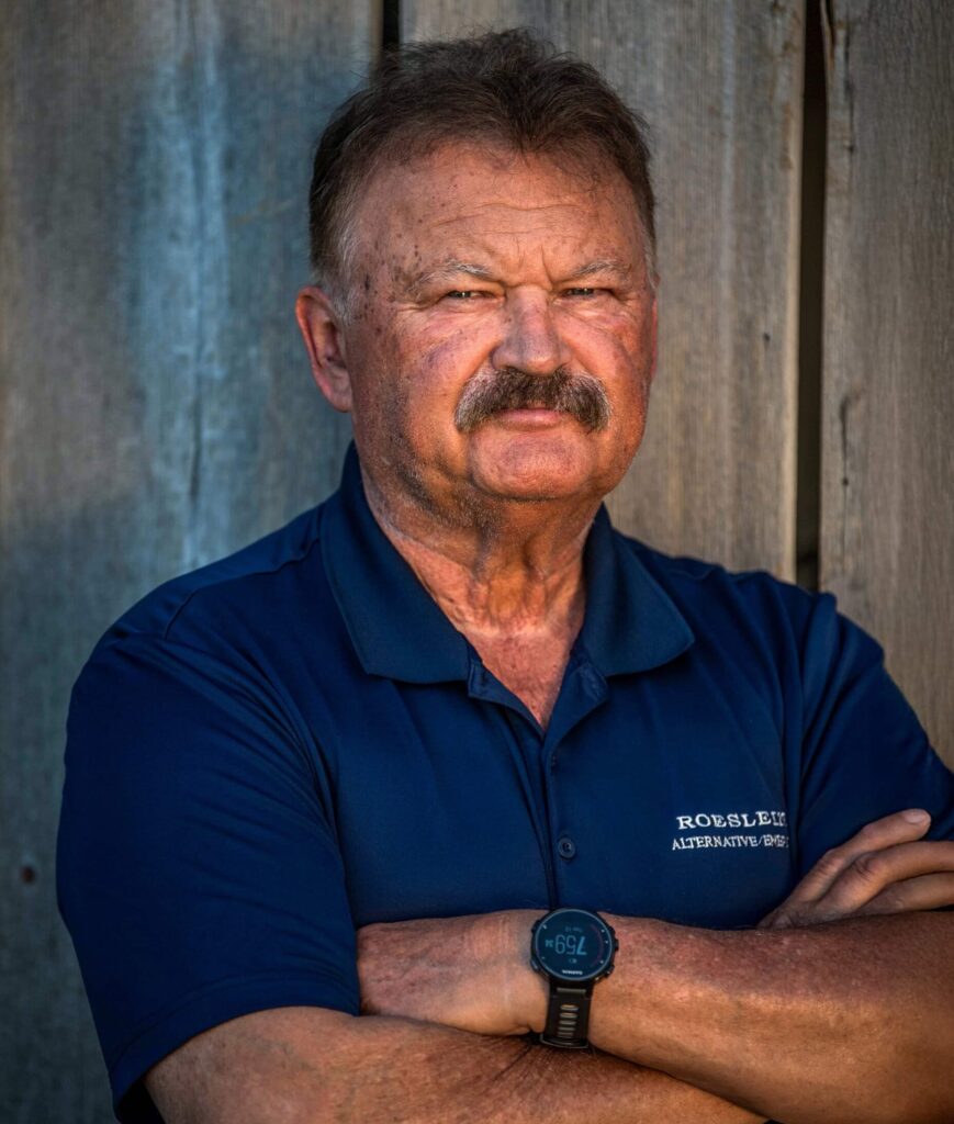 A profile photo of Rudi Roeslein standing with his arms crossed.